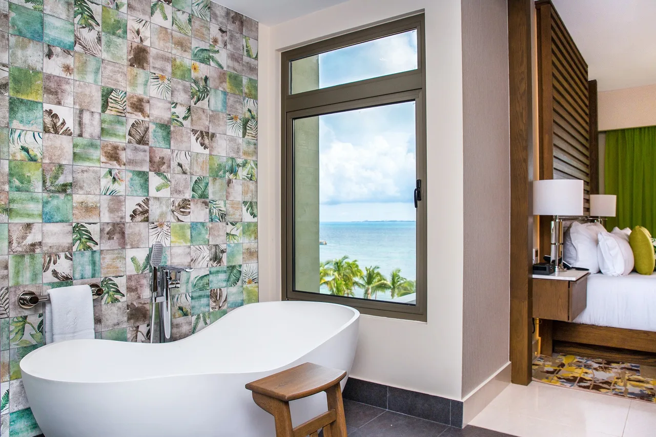 Free-standing soaking tub beside an ocean-view window